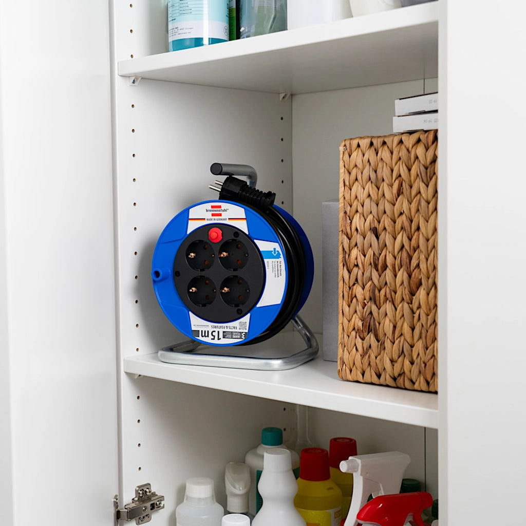 Eine Brennenstuhl Kabeltrommel steht in einem Haushaltsschrank.