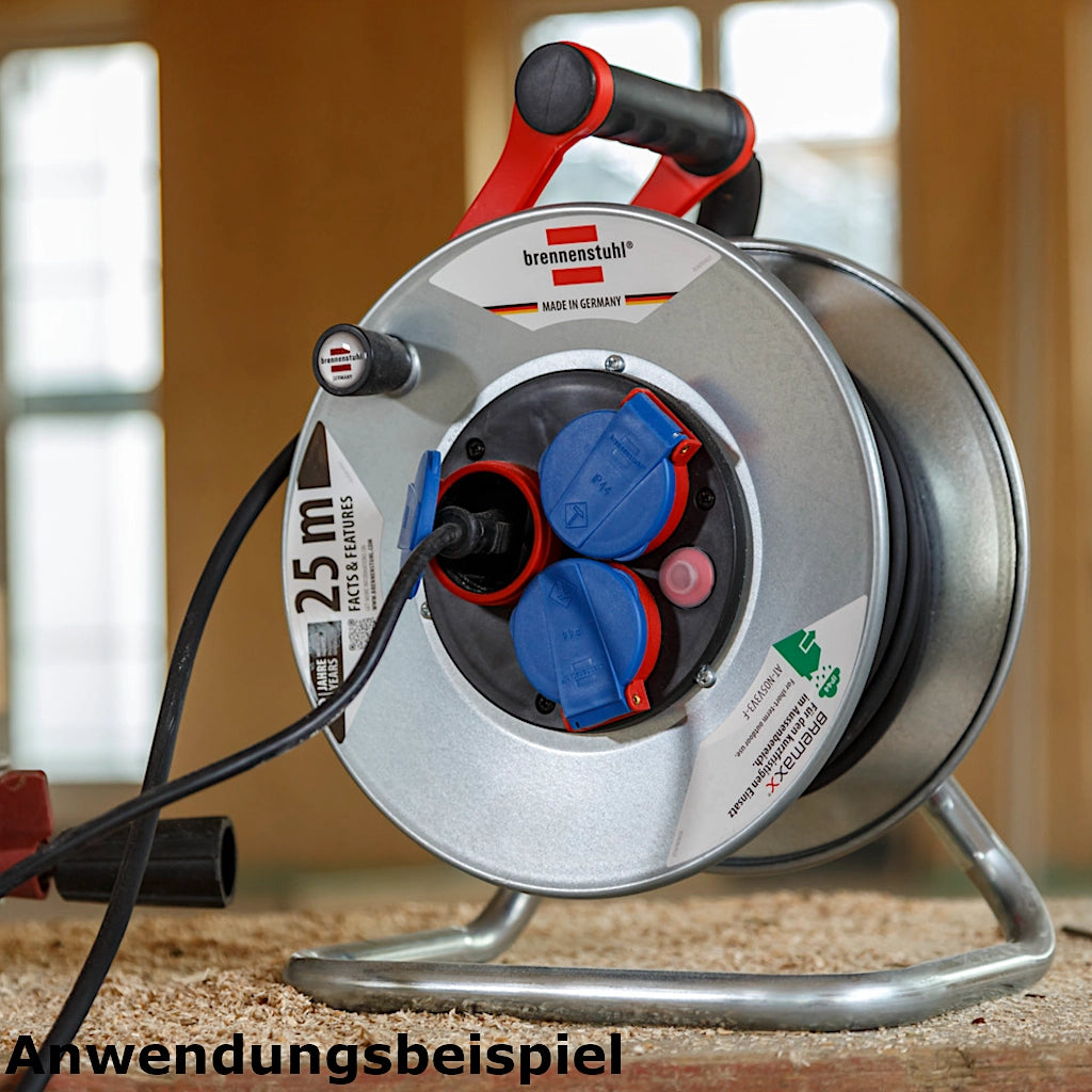 Brennenstuhl Kabeltrommel Garant S 3-fach 25m IP44 (1198580) auf dem Boden stehend auf eine Baustelle mit eingestecktem Kabel