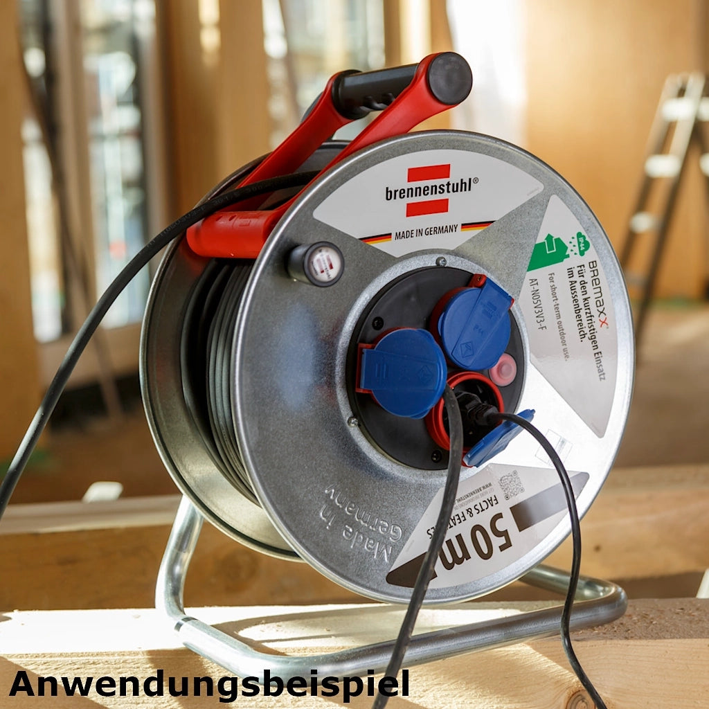 Eine Brennenstuhl Kabeltrommel Garant S 3-fach 50m steht auf einem Holzbalken auf einer Baustelle.