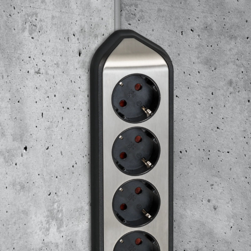 Eine Brennenstuhl Eck-Steckdosenleiste ist an einer grauen Betonwand in der Ecke vertikal montiert