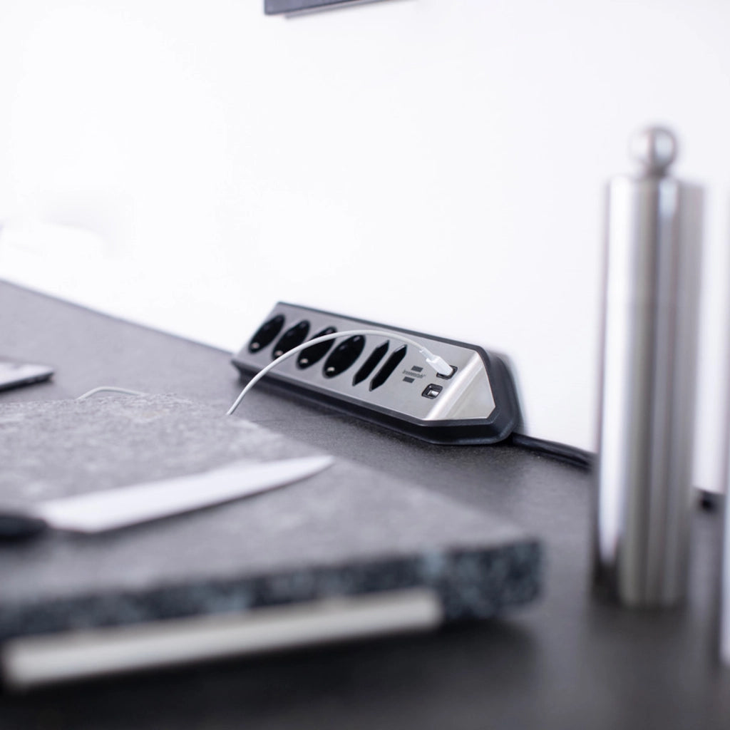 Eine Brennenstuhl Eck-Steckdosenleiste liegt auf einer grauen Küchenarbeitsplatte