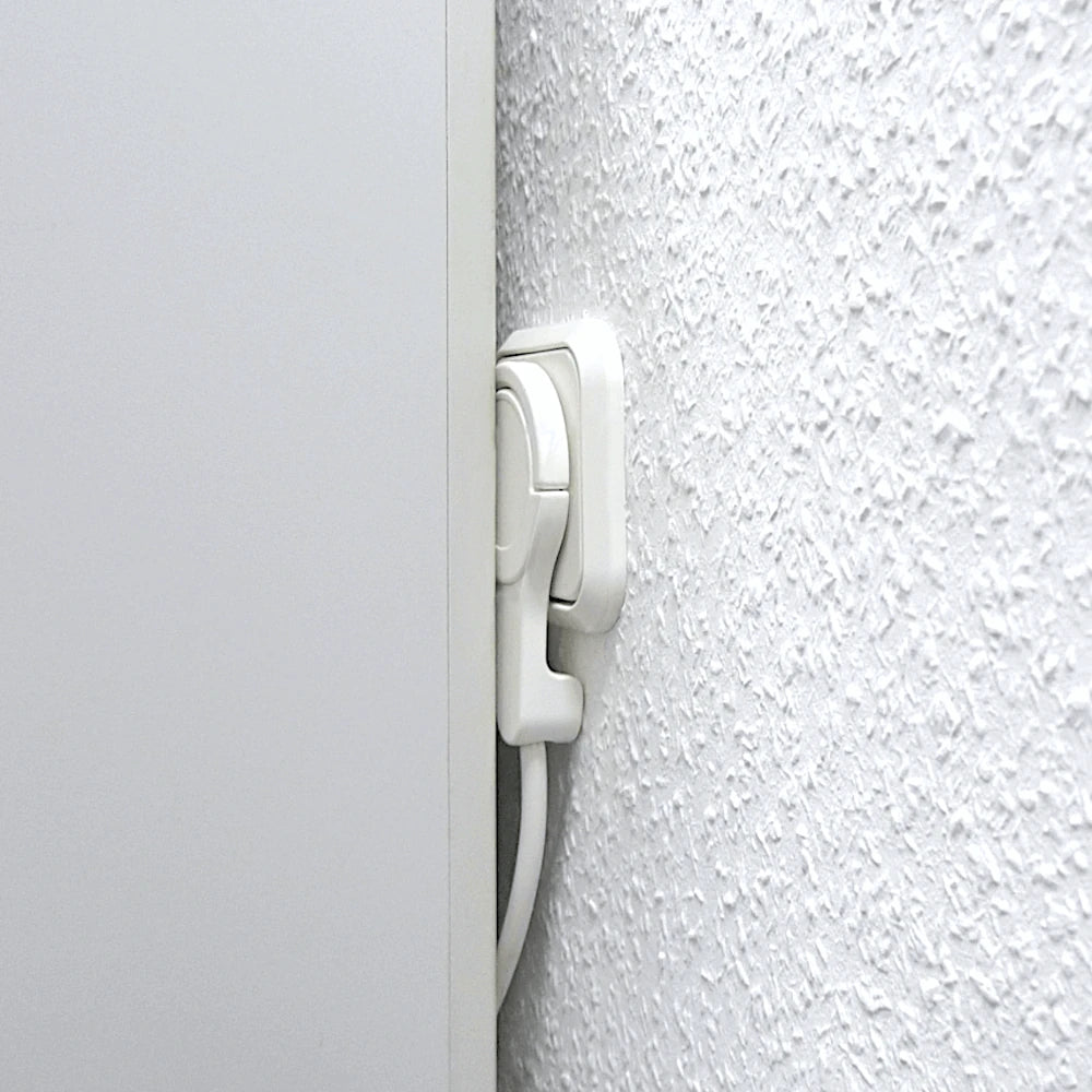 Kopp Winkelstecker extraflach Anwendungsbeispiel - der Stecker befindet sich in einer Steckdose hinter einem Schrank