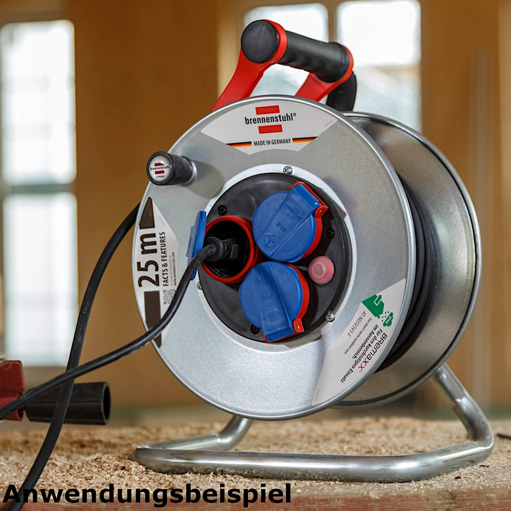 Brennenstuhl Kabeltrommel Garant S 3-fach 25m IP44 (1198580) auf dem Boden stehend auf eine Baustelle mit eingestecktem Kabel