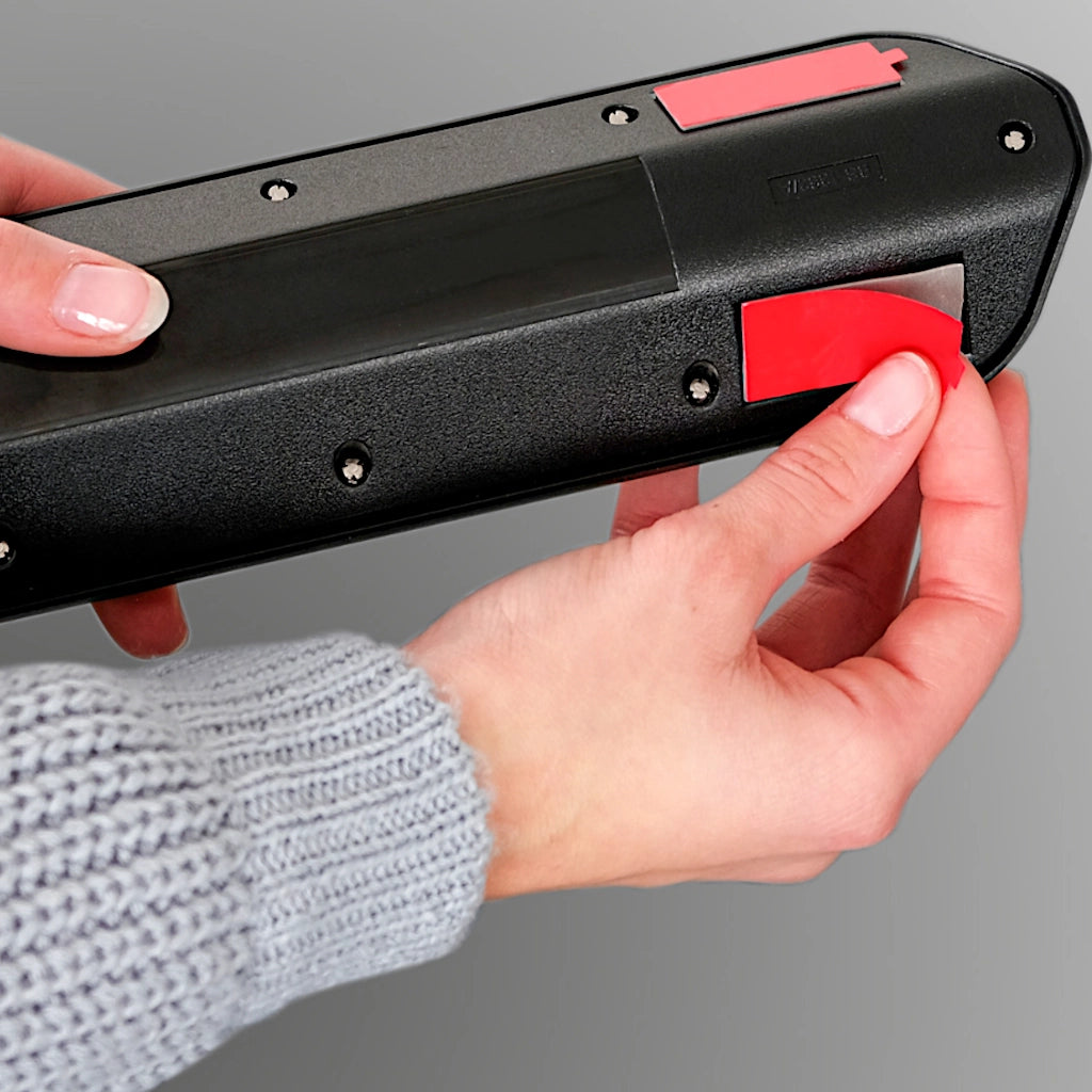 Es wird gezeigt, wie die Klebepads zu Befestigung der Brennenstuhl Ecksteckdose angebracht werden