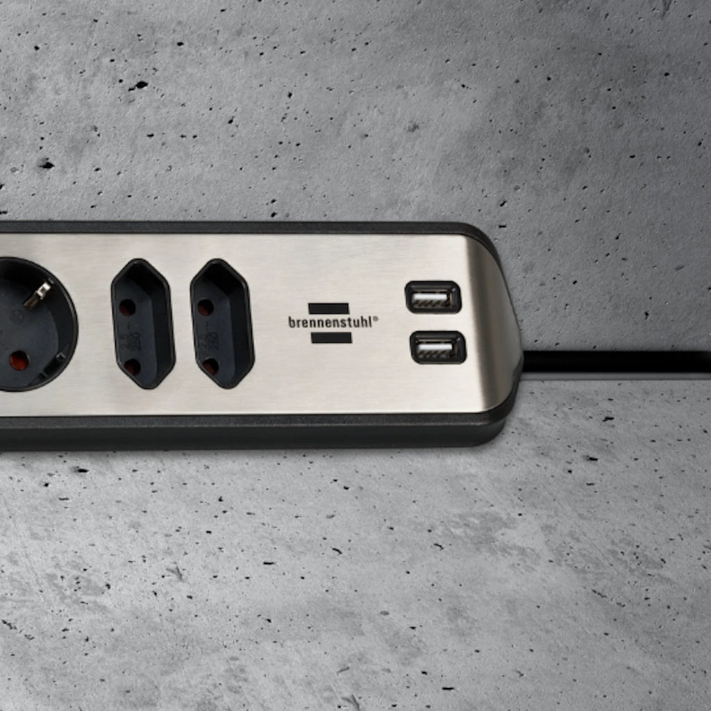 Eine Brennenstuhl Eck-Steckdosenleiste ist an einer grauen Betonwand in der Ecke horizontal montiert