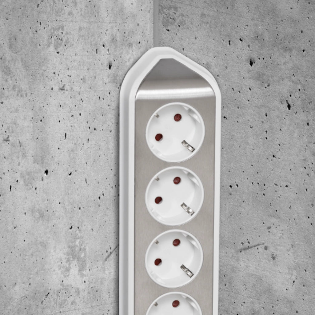 Eine Brennenstuhl Eck-Steckdosenleiste ist an einer grauen Betonwand in der Ecke vertikal montiert
