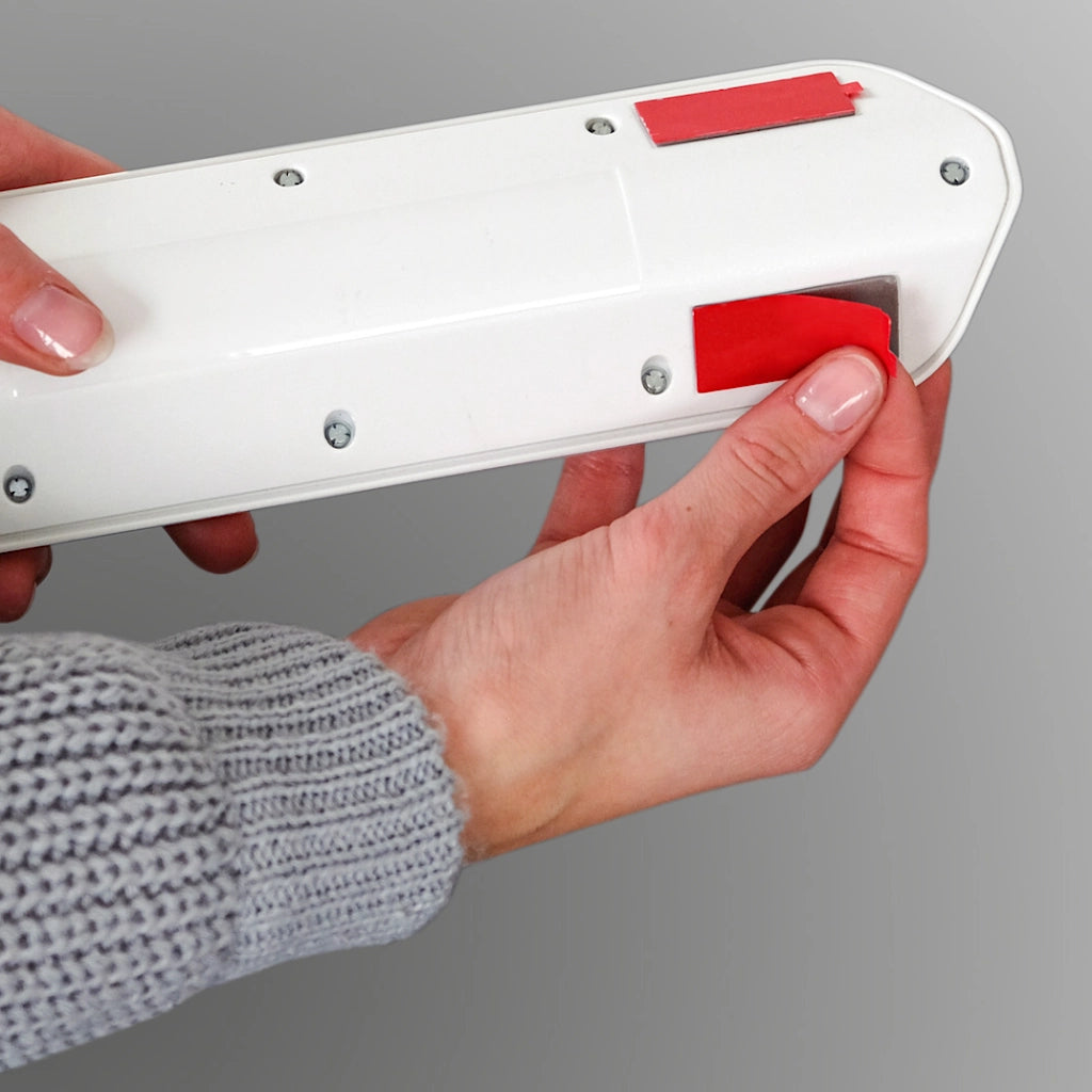 Es wird gezeigt, wie die Klebepads zu Befestigung der Brennenstuhl Ecksteckdose angebracht werden