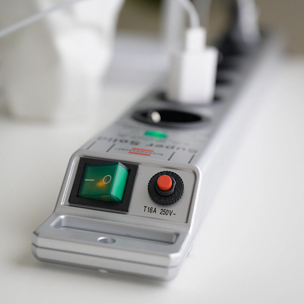 Eine silberne Brennenstuhl Steckdosenleiste mit Überspannungsschutz liegt auf einem Tisch