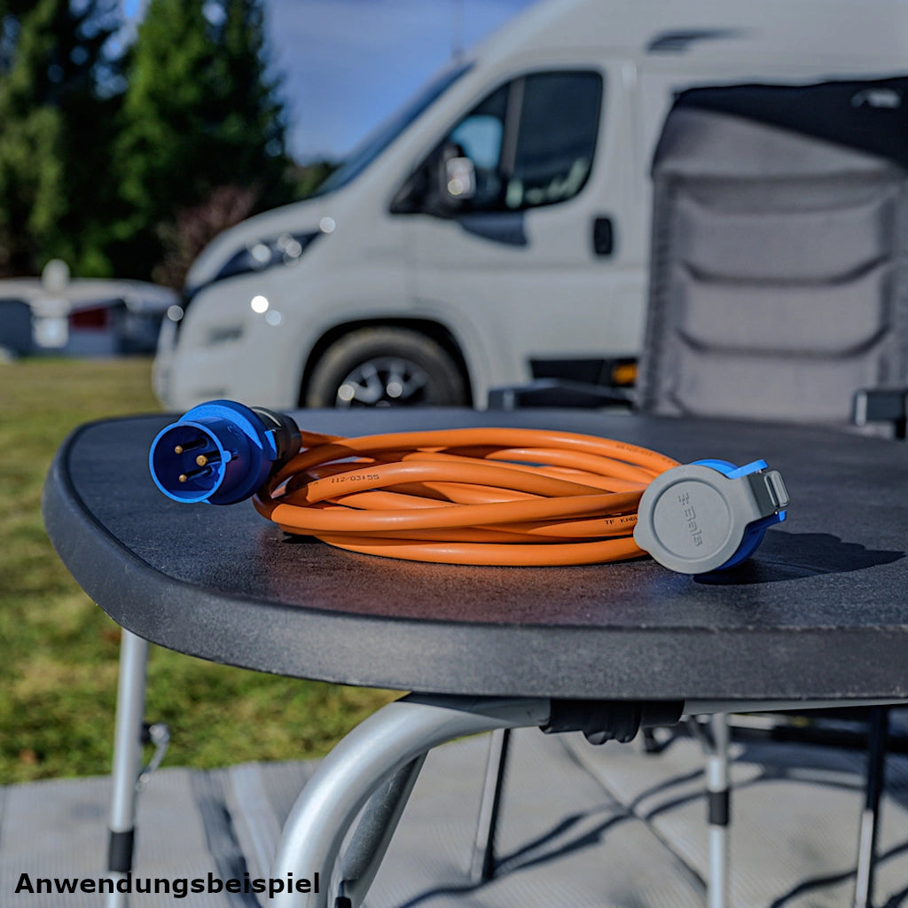 Ein Brennenstuhl Camping Verlängerungskabel in orange liegt auf einem grauen Tisch