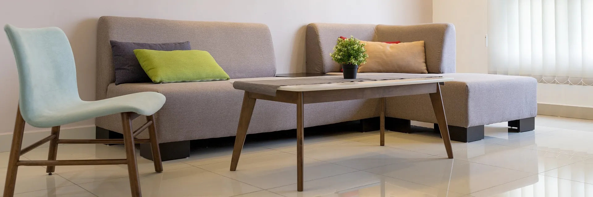 Vor einem modernen Sofa in Braun stehen ein Tisch und ein Stuhl